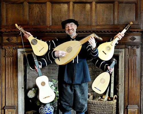 Ian the Minstrel holding multiple instruments