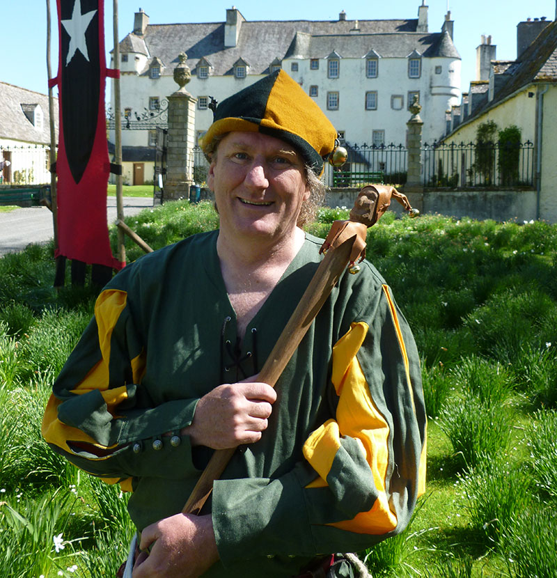 The Scottish jester standing outside a castle